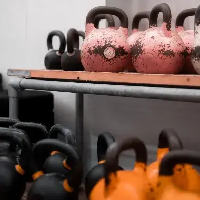 Colorful kettlebells lined up on the gym floor at Troy City Fitness