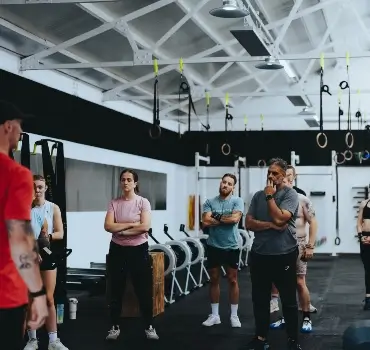 A group of members listening to a coach at Troy City Fitness
